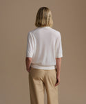 Person wearing a ivory courtney top and beige pants against a beige background