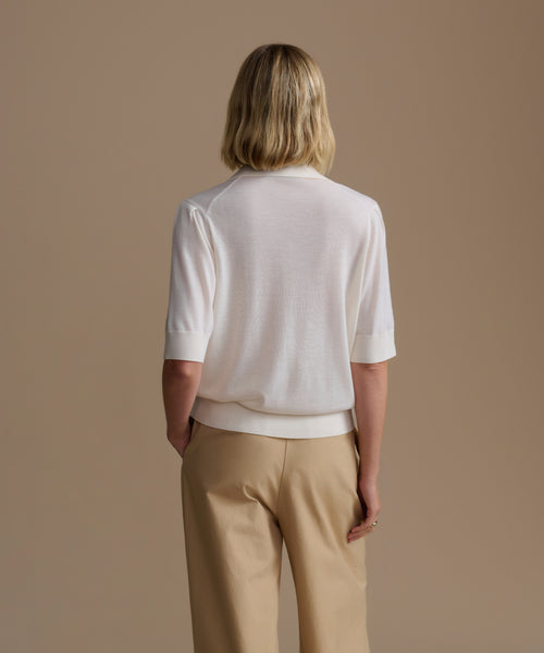 Person wearing a ivory courtney top and beige pants against a beige background