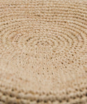 Close-up of the Crochet Raffia Sun Hat surface, showcasing a spiral pattern crafted from tightly woven natural fibers in light beige.