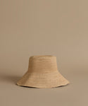 Beige woven hat on a beige background
