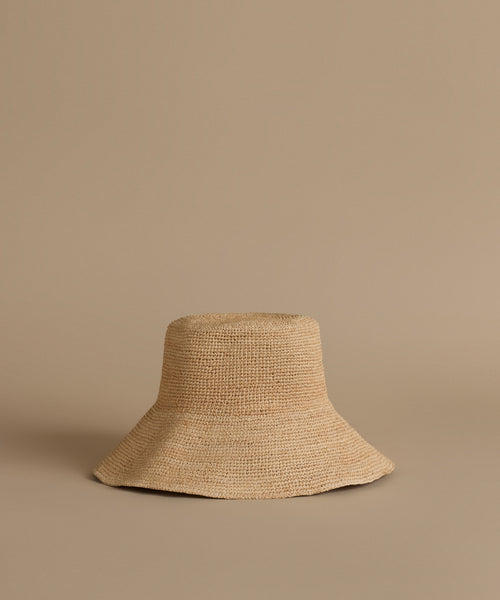 Beige woven hat on a beige background