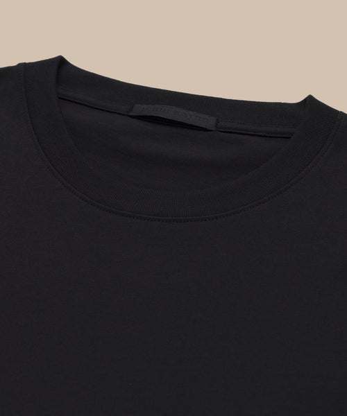 Close-up of the Crosby Tee’s neckline and upper chest, made from premium jersey cotton in a relaxed fit, shown laid flat on a beige background.