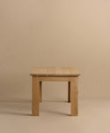 The Dining Table is a simple, handmade piece crafted from solid white oak, with a rectangular top and four straight legs. It is shown against a plain beige background.