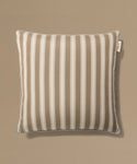 Striped pillow with a label on a beige background