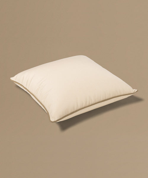 Beige pillow with a tag on a beige background
