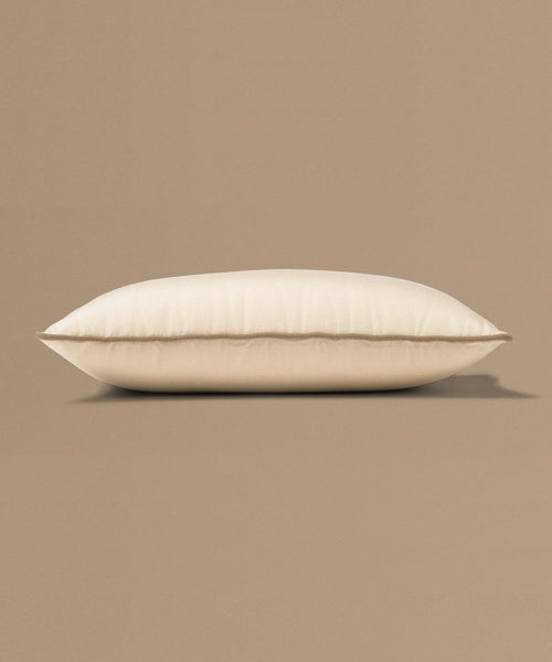 Beige pillow with a tag on a beige background