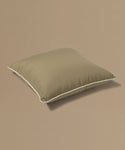 Brown pillow with a tag on a beige background