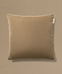 Brown pillow with a tag on a beige background