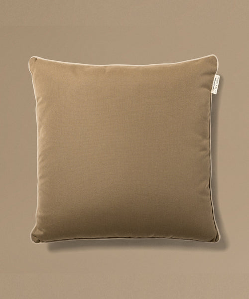 Brown pillow with a tag on a beige background