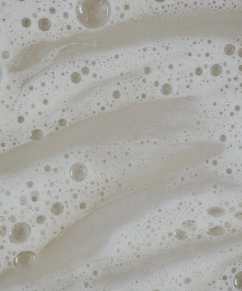 Close-up of soapy water with white foam and swirling bubbles, capturing the texture and movement typical when using the Travel Fresh Start Set.