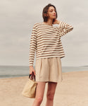 Woman wearing a striped sweater and shorts on a beach