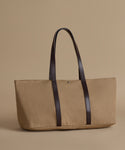 Beige tote bag with dark brown straps on a beige background