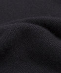 Close-up of the Grace Crewneck, a soft, deep black cashmere sweater with visible weave and gentle folds, highlighting its smooth and slightly fuzzy texture—ideal for lovers of luxury knitwear.