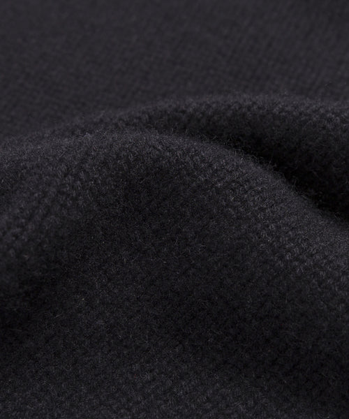 Close-up of the Grace Crewneck, a soft, deep black cashmere sweater with visible weave and gentle folds, highlighting its smooth and slightly fuzzy texture—ideal for lovers of luxury knitwear.