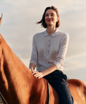 Woman sitting on a horse with a scenic background