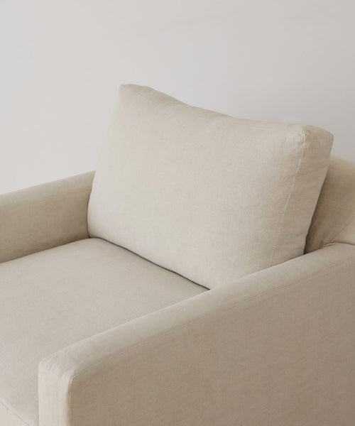 The Harbor Chair Slipcover is shown on a beige upholstered armchair with a square back cushion and natural linen fabric, set against a plain white background.