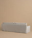 The Harbor Sofa, shown from the back against a beige background, features a light gray hue, handmade construction in Los Angeles, clean lines, and two seat cushions.