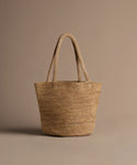 Woven straw tote bag on a brown background