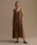Woman wearing a brown dress against a beige background