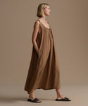 Woman wearing a brown dress against a beige background