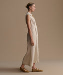 Woman wearing a beige dress against a plain background