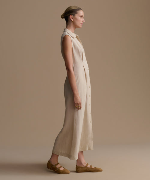 Woman wearing a beige dress against a plain background