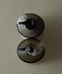 Two soap dispensers with black nozzles on a beige background