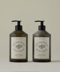 Two bottles of Oak Essentials Jenni Kayne hand care products on a beige background
