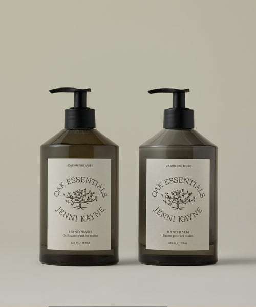 Two bottles of Oak Essentials Jenni Kayne hand care products on a beige background