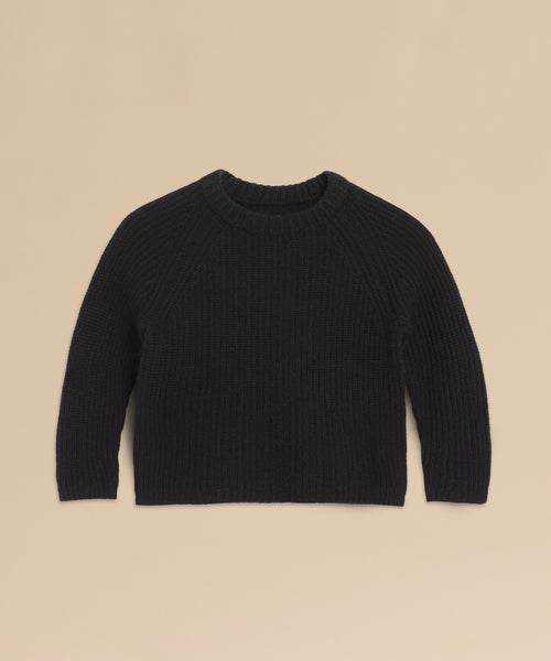 The Kids' Cashmere Fisherman, a black long-sleeve mini sweater with a crew neckline, is displayed flat on a beige background—an ideal cozy kids’ sweater for any occasion.