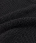 Close-up of the Kids' Cashmere Fisherman sweater in black, showing its textured fabric with visible woven patterns and soft raised ridges for a cozy, warm look.