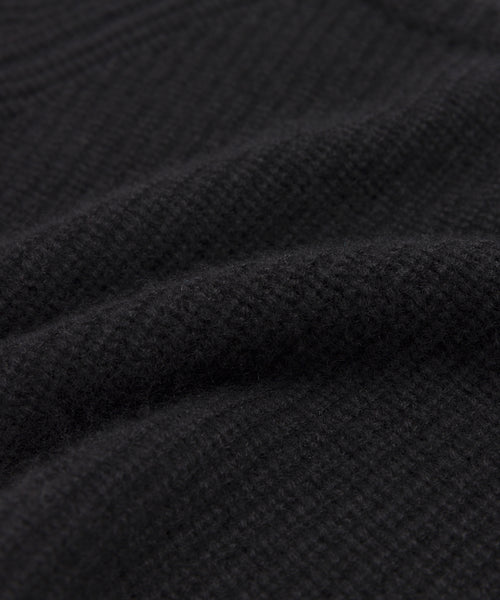 Close-up of the Kids' Cashmere Fisherman sweater in black, showing its textured fabric with visible woven patterns and soft raised ridges for a cozy, warm look.