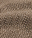 Close-up of the Kids' Cashmere Fisherman sweater in brown, featuring textured, evenly spaced stitches and gentle waves that highlight its soft, cozy cashmere material.