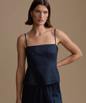 Woman wearing a navy kinney cami against a beige background