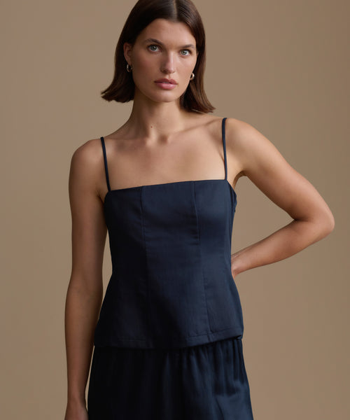 Woman wearing a navy kinney cami against a beige background