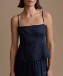 Woman wearing a navy kinney cami against a beige background