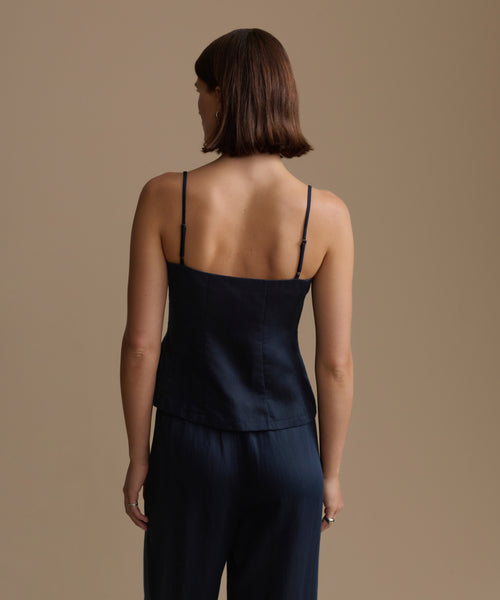 Woman wearing a navy kinney cami and pants against a beige background