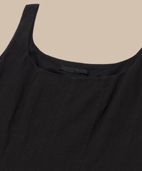 Close-up of the Kinney Dress, a sleeveless black summer dress featuring a scoop neckline, displayed against a neutral beige background.