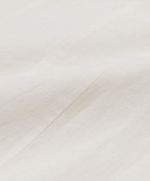 Close-up of soft, off-white washed linen with subtle texture and gentle folds, highlighting the smooth, slightly woven surface of the Kinney Dress—ideal for summer wear.