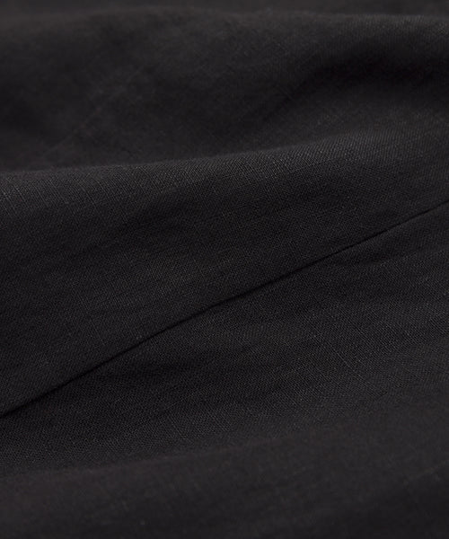 Close-up of black fabric with soft folds and fine texture, showcasing the lightweight linen of the Kinney Skirt—perfect for summer.