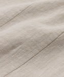 Close-up of the Kinney Skirts beige linen fabric highlights its natural texture, visible fibers, and diagonal seams, making this lightweight skirt soft and ideal for summer wear.
