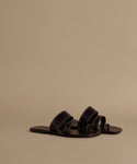 Pair of black sandals on a beige background