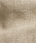 Close-up of beige burlap fabric with a coarse, woven texture and visible threads, echoing the natural fibers and artisanal quality of the Linen Bucket Hat made in Portugal.