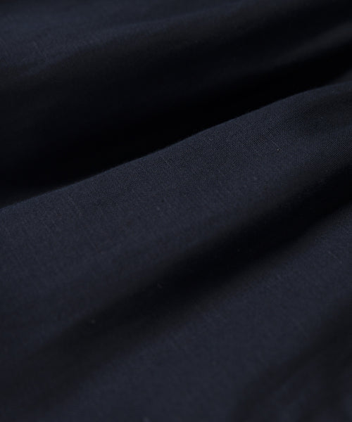 A close-up of the Logan Short’s dark, smooth fabric reveals soft folds and a gently textured surface with a satin-like, elegant finish.