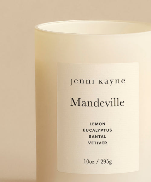 The Mandeville Glass Candle is hand-poured in Los Angeles with cream-colored wax in a frosted jar and features scent notes of lemon, eucalyptus, santal, and vetiver. Size: 10 oz / 295 g.