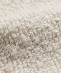 Close-up of a textured, cream-colored fabric with small loops and a soft, bumpy surface, like the Fabric Swatch Oyster Mini Boucle.