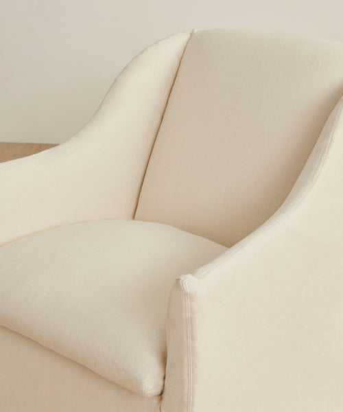 A close-up view of the Miramar Chair Slipcover in cream, featuring soft, rounded edges and a smooth pearl linen texture.