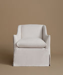 A white upholstered armchair with a matching back cushion, shown against a solid warm taupe background.
