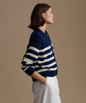 Woman wearing a navy and white striped sweater against a beige background