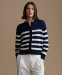 Woman wearing a navy and white striped sweater against a beige background